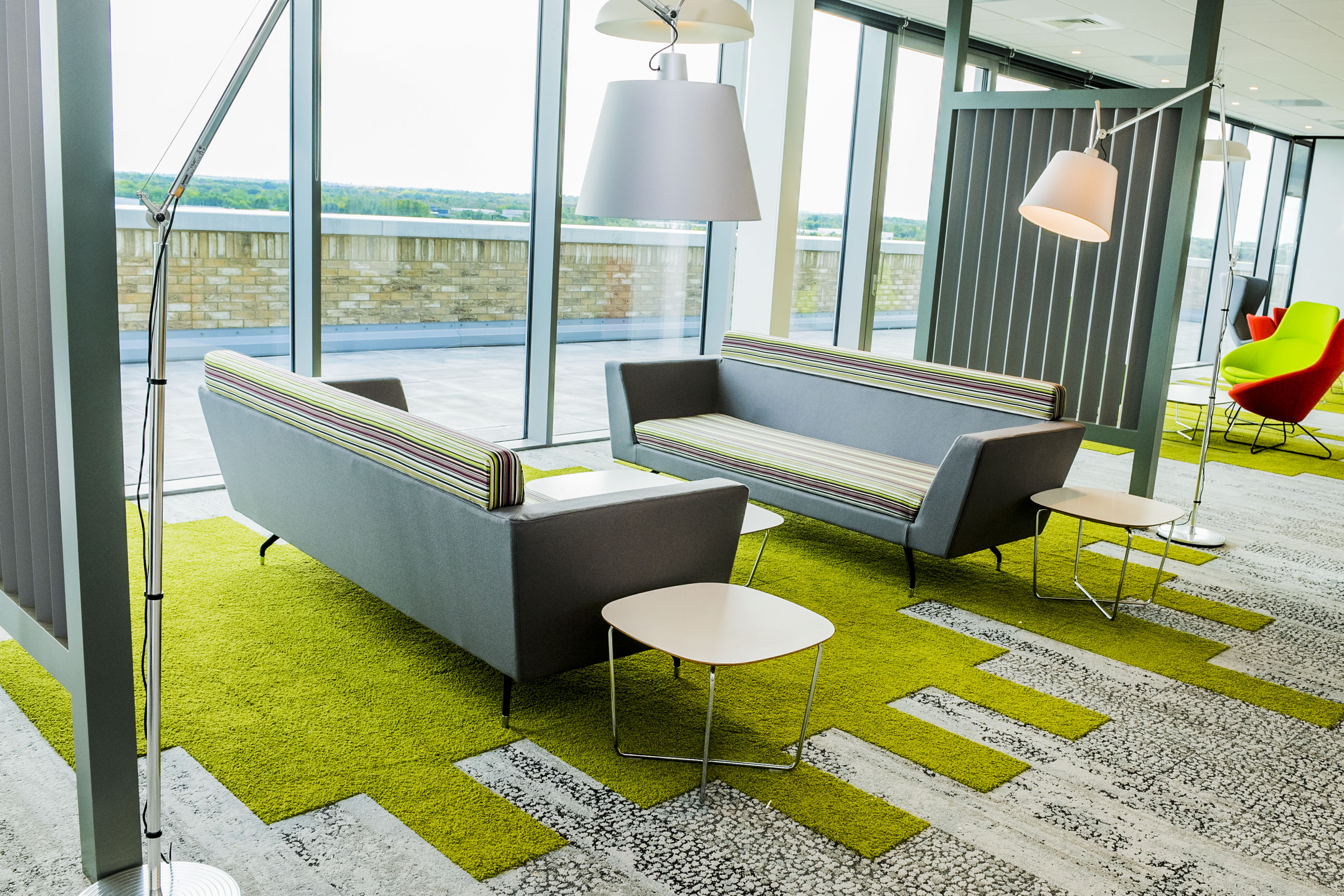 A breakout area in the Milton Keynes office, with two sofas facing each other with tables alongside. 